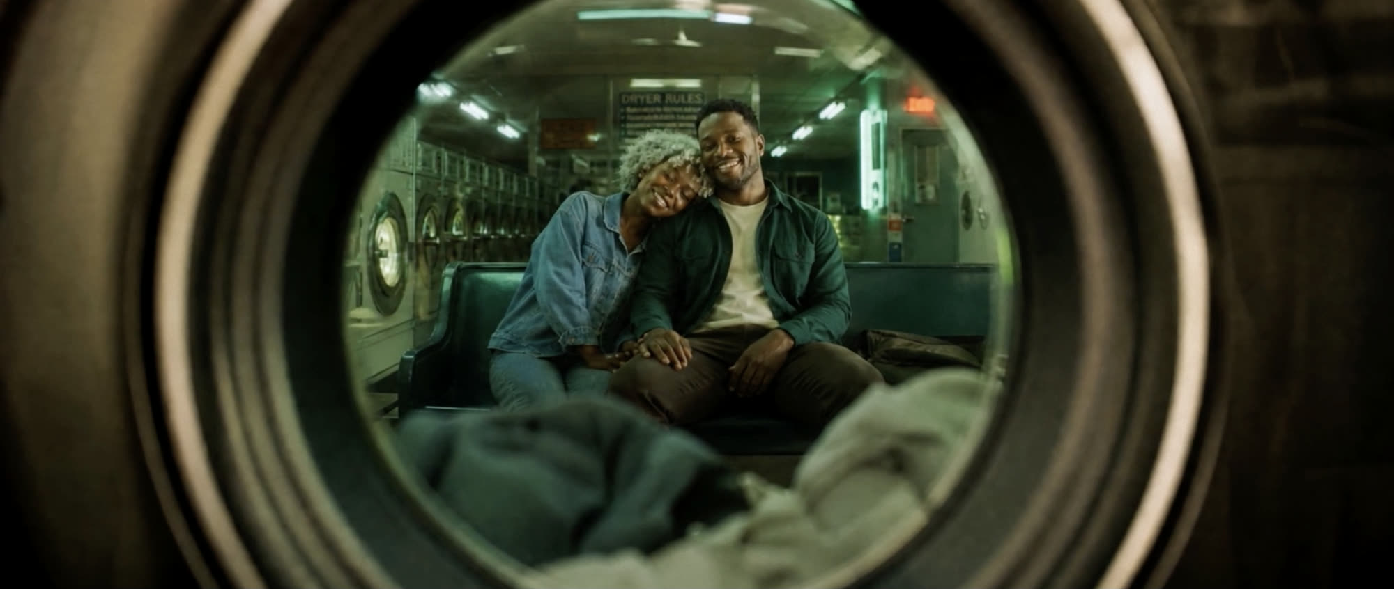 Quest — frame from the film, a couple seen through a laundromat window